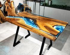 a table made out of wood and glass with blue water on the top is shown