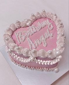 a heart shaped birthday cake with pearls on the edges and congratulations written in white frosting