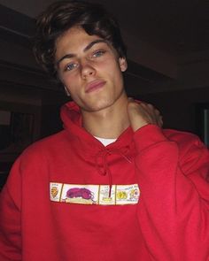 a young man in a red hoodie is holding another mans neck