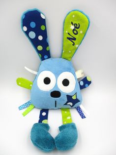 a blue and green stuffed animal with polka dots on it's ears, eyes and legs