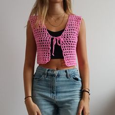 a woman wearing jeans and a pink crochet top