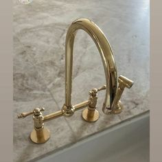 two faucets on the side of a sink in a bathroom with marble counter tops