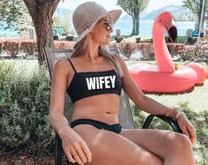 a woman sitting on top of a chair next to an inflatable flamingo