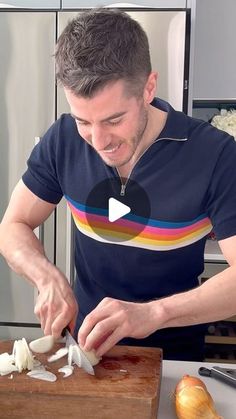 a man cutting onions on top of a wooden cutting board