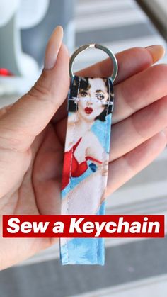 a woman's hand holding a keychain with an image of herself on it