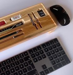 a keyboard and mouse sitting next to each other on a white table with a wooden case