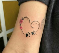 a woman's arm with a heart shaped tattoo on it