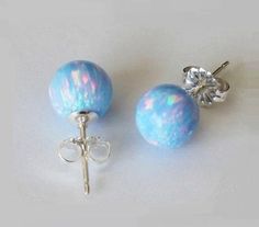 This listing is for a pair of lab created 6mm or 8mm ice blue opal ball studs, matched with solid sterling silver ear posts and safety nuts. A pair of silicone ear stoppers will also be included. Also available in 14K gold filled, Pure Titanium, and surgical steel ear posts and backs for your selection. *These lab created opals have similar properties and make ups as natural opal, the only difference is they are created in the lab instead of naturally occurred. They have multiple flashes in them Unique Drop Earrings, Blue Opal Earrings, Island Crafts, Blue Fire Opal, Opal Stud Earrings, Geode Earrings, October Birthday, Opal Earrings Stud, Opal Studs