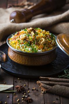 a bowl filled with food sitting on top of a table next to spices and utensils