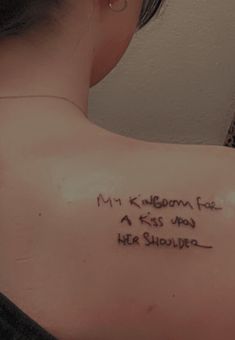 the back of a woman's shoulder with writing on it that says, my kingdom has a kiss upon her shoulder