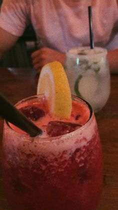 a person sitting at a table with a drink