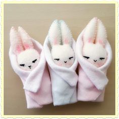 three little stuffed animals wrapped in blankets