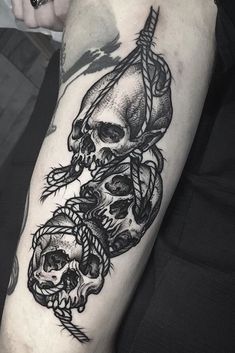 a person with a tattoo on their arm that has two skulls and arrows in it