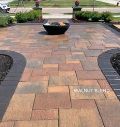 a brick patio with an outdoor fire pit in the middle