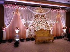 a chair sitting in front of a stage decorated with flowers and candles for a wedding