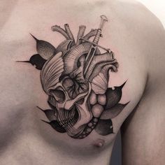 a man's chest with a heart and arrow tattoo on his left side shoulder