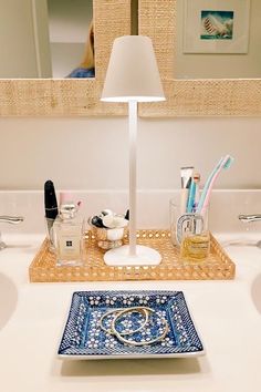 the bathroom sink is clean and ready to be used as a vanity mirror, soap dispenser, toothbrushes, and other items