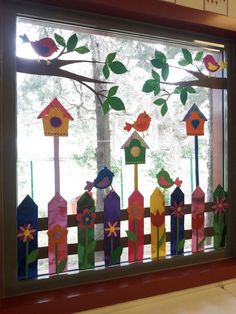 a window decorated with colorful birds and birdhouses