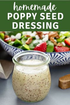 homemade poppy seed dressing in a glass jar next to a salad with strawberries and walnuts