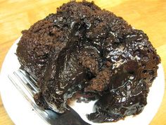 a piece of chocolate cake sitting on top of a white plate next to a fork