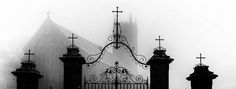 a black and white photo of a church in the fog