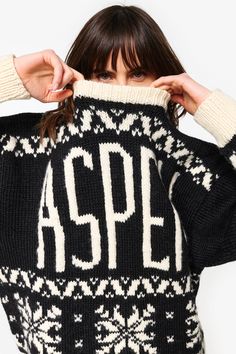 a woman wearing an ugly sweater with the word aspe written in white on it