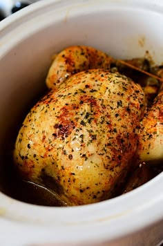 three pieces of chicken in a crock pot with some spices on top of it