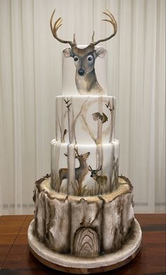 a three tiered cake decorated with deer heads