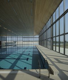 an empty indoor swimming pool with large windows