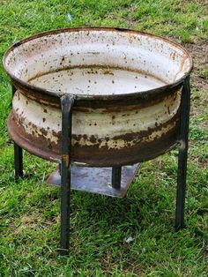 an old metal tub sitting in the grass