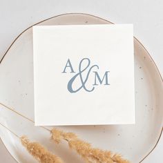 a white plate topped with a paper and a couple initials on top of each other