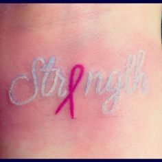 the word strength written in white ink with a pink ribbon on it's side