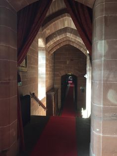 a hallway with red carpet and brick walls