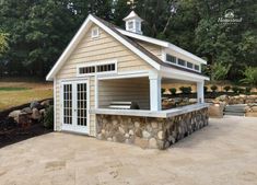 a small shed with a stone wall and roof