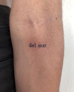 a person with a tattoo on their arm that says del mar in black ink,