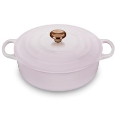 a white casserole dish with a gold knob on the top and bottom lid