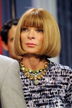 a close up of a person wearing a suit and necklace on the set of tv show good morning america