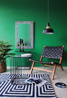 a living room with green walls and black accents