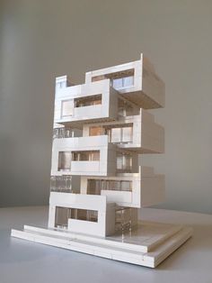 a model of a building on top of a white surface with windows and balconies