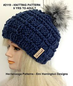 a mannequin head wearing a knitted hat with a pom - pom