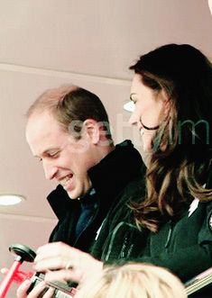 a man playing the trumpet with two women and a young boy looking at his cell phone