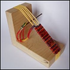 an object made out of wood and stringing on top of a wooden stand with wires attached to it