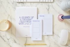 the contents of a personal planner laid out on a marble table with a keyboard, mouse and other office supplies