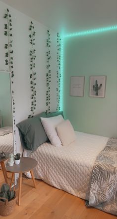 a bed room with a neatly made bed and green plants on the wall