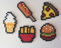 four pixel art magnets depicting different foods and beverages on white surface, with one being an ice cream cone