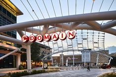 the entrance to a shopping mall with red and white signs hanging from it's sides