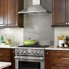 a stove top oven sitting inside of a kitchen next to wooden cabinets and counter tops