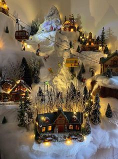 a christmas village with lights and snow covered trees