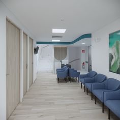 an empty waiting room with blue chairs in it