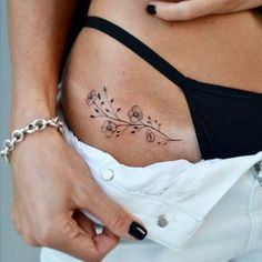 a woman's stomach with a tattoo on her belly and flowers in the middle